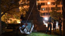 A group of people toppling a monument.
