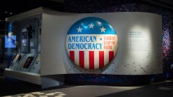 A museum display with a large button reading 'AMERICAN DEMOCRACY.'