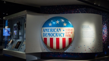 A museum display with a large button reading 'AMERICAN DEMOCRACY.'